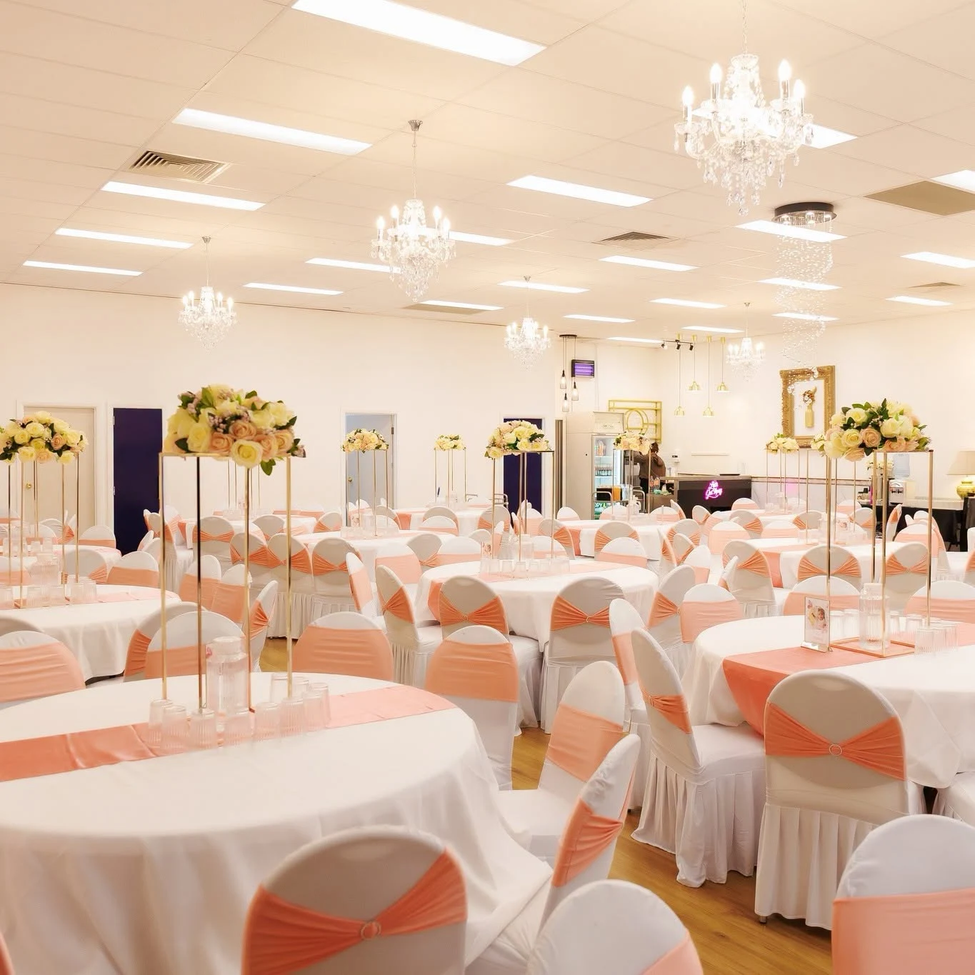 KTM Banquets room with peach chair sashes and floral centrepieces